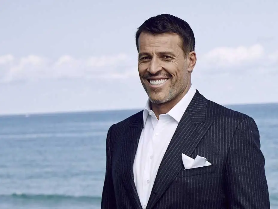 Tony Robbins de terno na praia: poder sem limites